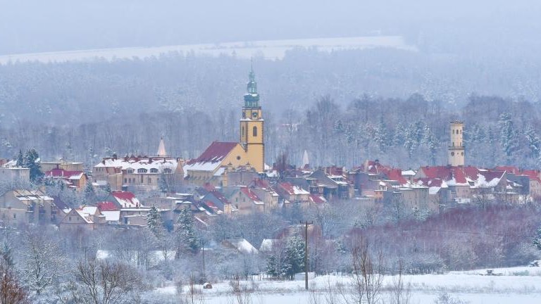 shutterstock_2144188329 Panorama of the city of Bystrzyca Kłodzka, the view from the hill to the snow-covered city on a cloudy day..jpg